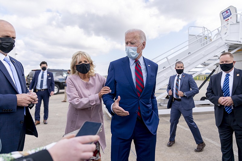 FILE - In this Oct. 5, 2020 file photo, Jill Biden moves her husband, Democratic presidential candidate former Vice President Joe Biden, back from members of the media as he speaks outside his campaign plane at New Castle Airport in New Castle, Del., to travel to Miami for campaign events. Protecting Joe stands out among Jill Biden's many roles over their 43-year marriage, as her husband's career moved him from the Senate to the presidential campaign trail and the White House as President Barack Obama's vice president. She's a wife, mother, grandmother and educator with a doctoral degree — as well as a noted prankster who will soon be putting her own stamp on what it means to be first lady. (AP Photo/Andrew Harnik, File)