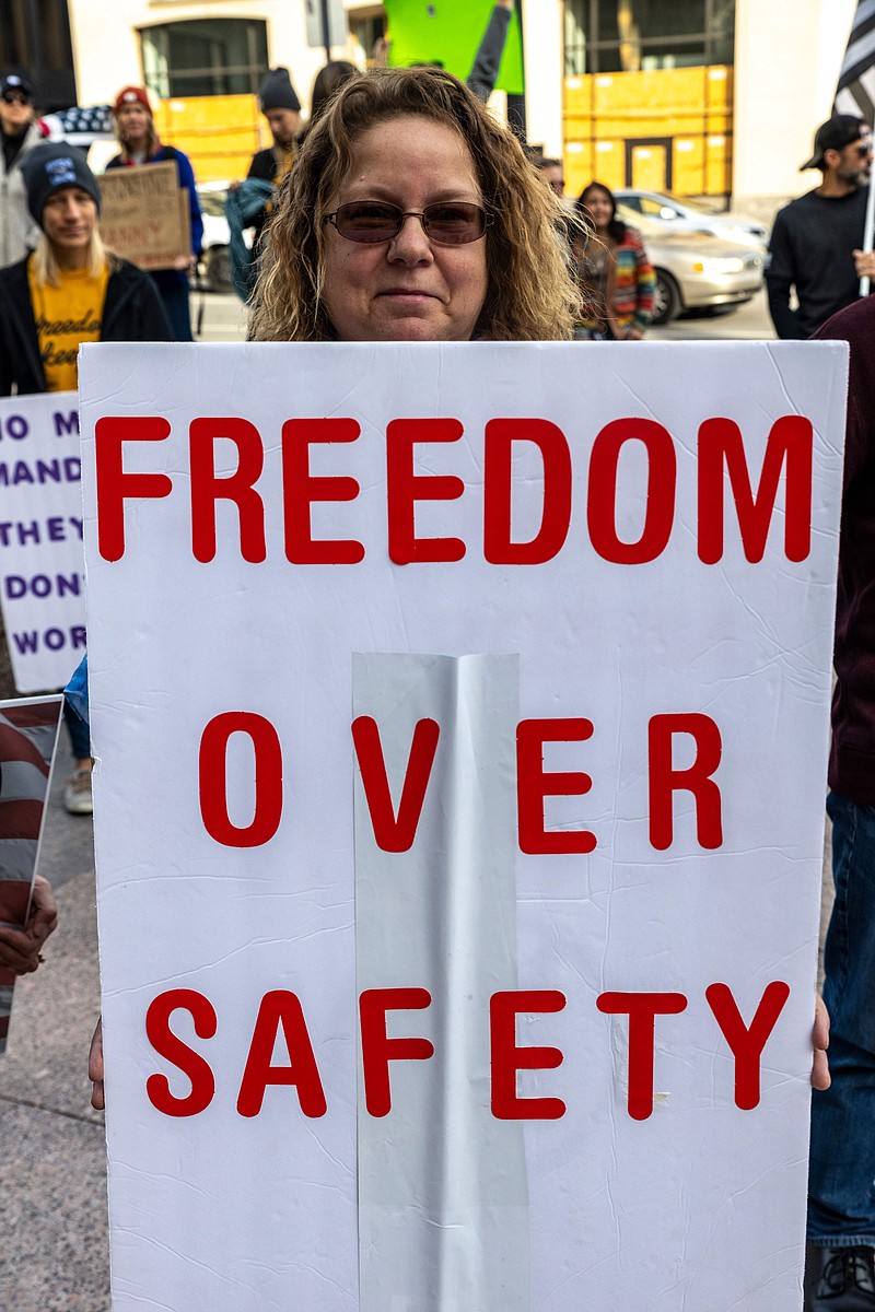 A woman holds a "Freedom over Safety" sign during the "Save Ohios Restaurants and Bars: We Cant Afford Another Shutdown" protest against Covid-19 restrictions in Ohio, November 19, 2020 in Columbus, Ohio. California and Ohio, two of the largest US states will begin night-time curfews to combat a surge in Covid-19. (Stephen Zenner/AFP via Getty Images/TNS)