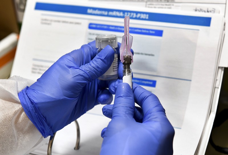 FILE - In this July 27, 2020, file photo, nurse Kathe Olmstead prepares a shot that is part of a possible COVID-19 vaccine, developed by the National Institutes of Health and Moderna Inc., in Binghamton, N.Y. Moderna Inc. says it will ask U.S. and European regulators to allow emergency use of its COVID-19 vaccine as new study results confirm the shots offer strong protection. (AP Photo/Hans Pennink, File)