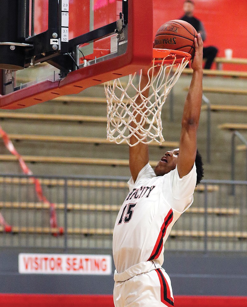 Sterling DeSha of Jefferson City dunks the ball in the first quarter of Tuesday's game against Monroe City at Fleming Fieldhouse.