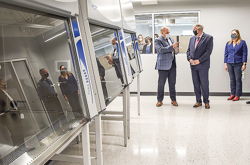 Rep. Sara Walsh, right, and Gov. Mike Parson listen as Brian Hoey, left, describes the function of the equipment in front of them Wednesday during a tour of the new crime lab at the Missouri Highway Patrol Headquarters. Hoey is director of the crime lab and was on hand at for the ribbon-cutting ceremony