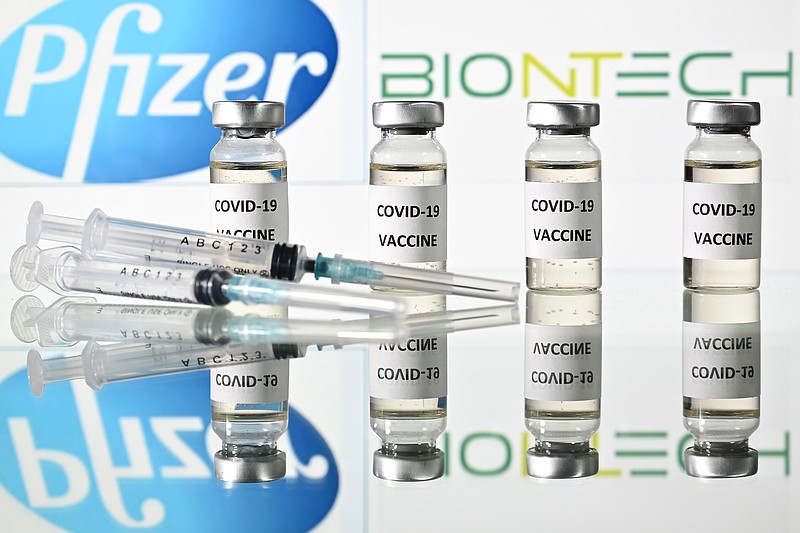 An illustration picture shows vials with Covid-19 Vaccine stickers attached and syringes with the logo of US pharmaceutical company Pfizer and German partner BioNTech, on November 17, 2020. (Justin Tallis/AFP/Getty Images/TNS)