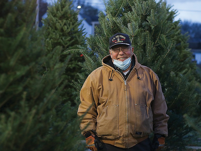 Walt Shull stands on the grounds of the Christmas tree lot set up between the JC Optimist Club and Hawthorn Bank. Shull, an Optimist Club member, helps at the lot every year. 