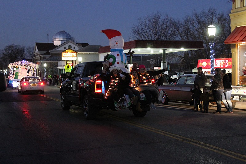 <p>Democrat photo/Austin Hornbostel</p><p>The staff of Something Sassy waves as their float cruises down Oak Street during Saturday’s Christmas parade.</p>