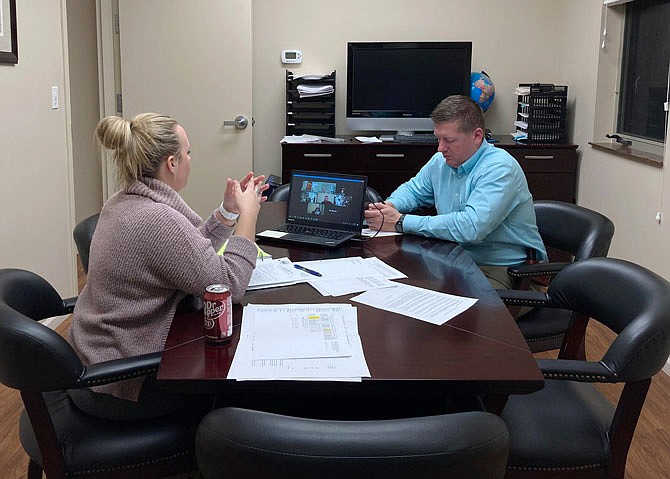 City Administrator Hanna Lechner and Holts Summit Police Department Sgt. Brandon Ruediger talk Tuesday night with the Holts Summit Board of Aldermen in an adjacent room due to technical difficulties. Ruediger was appointed as the city's Emergency Management Director during the meeting.