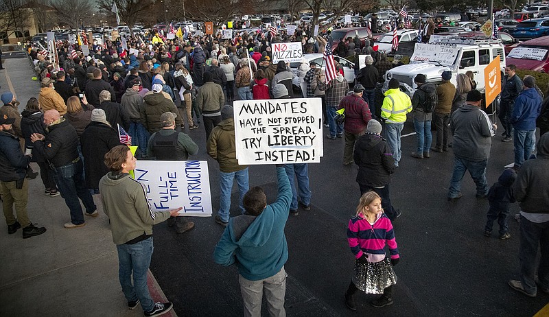 FILE - In this Dec. 8, 2020, file photo, anti-masker demonstrators converge on Central District Health offices in Boise, Idaho, to the protest a meeting deciding on more mandates to combat the spread of COVID-19. Arguments over mask requirements and other restrictions have turned ugly in recent days as the deadly coronavirus surge engulfs small and medium-size cities that once seemed a safe remove from the outbreak. (Darin Oswald/Idaho Statesman via AP, File)