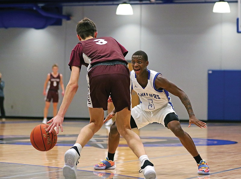 Capital City's Robert Gray defends Strafford's AK Rael during Saturday's game at Capital City High School.