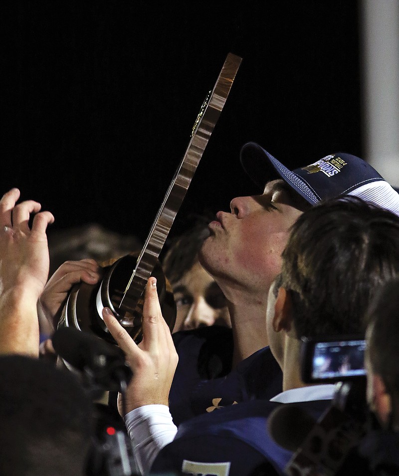 Helias' Zach Wolken kisses the Class 4 state championship trophy Dec. 4 after the Crusaders defeated the MICDS Rams at Adkins Stadium.