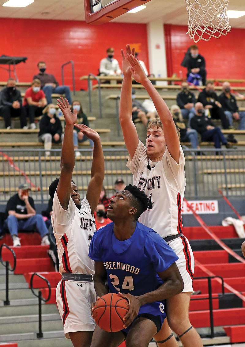 Jefferson City teammates DaShawn Webster (left) and Parker Gourley guard Greenwood's Aminu Mohammed during Saturday's game at Fleming Fieldhouse.