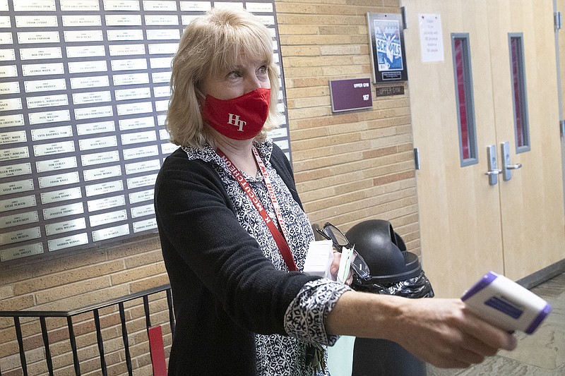 Kathy McCutcheon, a school nurse at Haddon Township High School, takes a temperature at the door during a remote learning school day on Wednesday, Nov. 25, 2020. (HEATHER KHALIFA/The Philadelphia Inquirer/TNS)