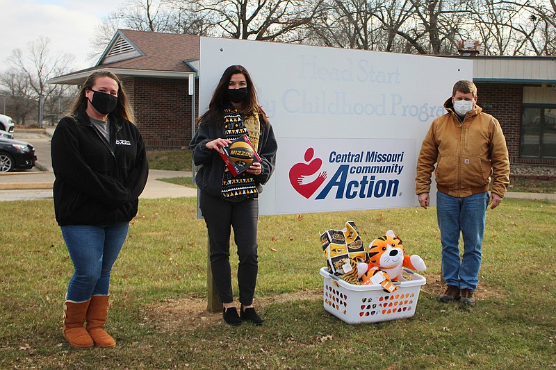 Lisa Cumins and Kellie Pontius of Central Missouri Community Action accept a donation of toys from the Callaway County Chapter of the Mizzou Alumni Association.