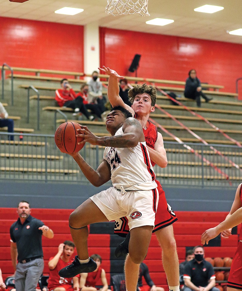 Jefferson City's Kevion Pendelton attempts a shot while getting fouled by Ozark's Kyle Flavin during Friday night's game at Fleming Fieldhouse.