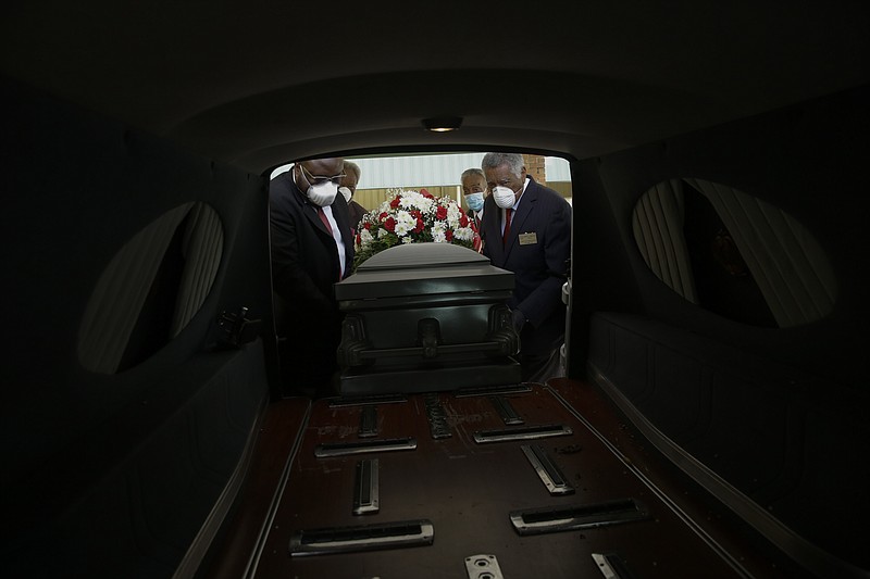 FILE - In this Saturday, April 18, 2020 file photo, mortician Cordarial O. Holloway, foreground left, funeral director Robert L. Albritten, foreground right, and funeral attendants Eddie Keith, background left, and Ronald Costello place a casket into a hearse in Dawson, Ga. This is the deadliest year in U.S. history, with deaths topping 3 million for the first time. It's due mainly to the coronavirus pandemic that has killed nearly 320,000 Americans. (AP Photo/Brynn Anderson)