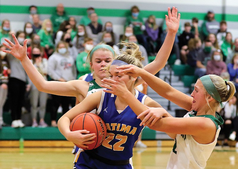 Blair Oaks teammates Alyssa Hargus (back) and Bailey Rissmiller try to wrestle the ball away from Fatima's Ellie Brune during Tuesday's game in Wardsville.
