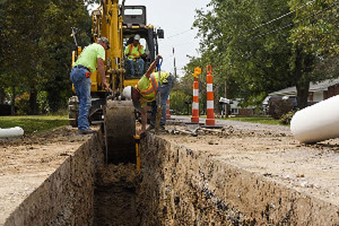 FILE: Bernie Nadler, left, probes the dirt Sept. 23 as Jason McDonald uses a locator to find utility lines during sewer construction at the corner of Nieman and Halifax roads in Holts Summit.