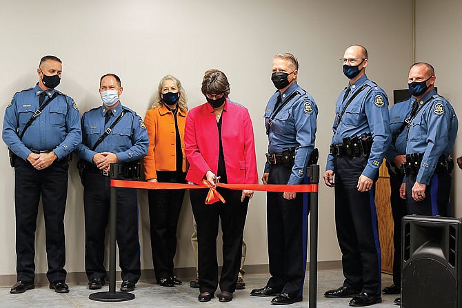 Department of Public Safety Director Sandy Karsten, center, cuts the ribbon Wednesday to symbolically open the Missouri Highway Patrol's new outdoor firing range.