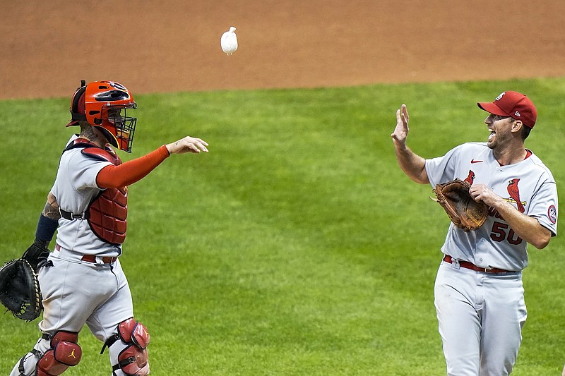 In this Sept. 16 file photo, Cardinals catcher Yadier Molina throws Adam Wainwright a rosin bag after the first game of a doubleheader against the Brewers in Milwaukee.