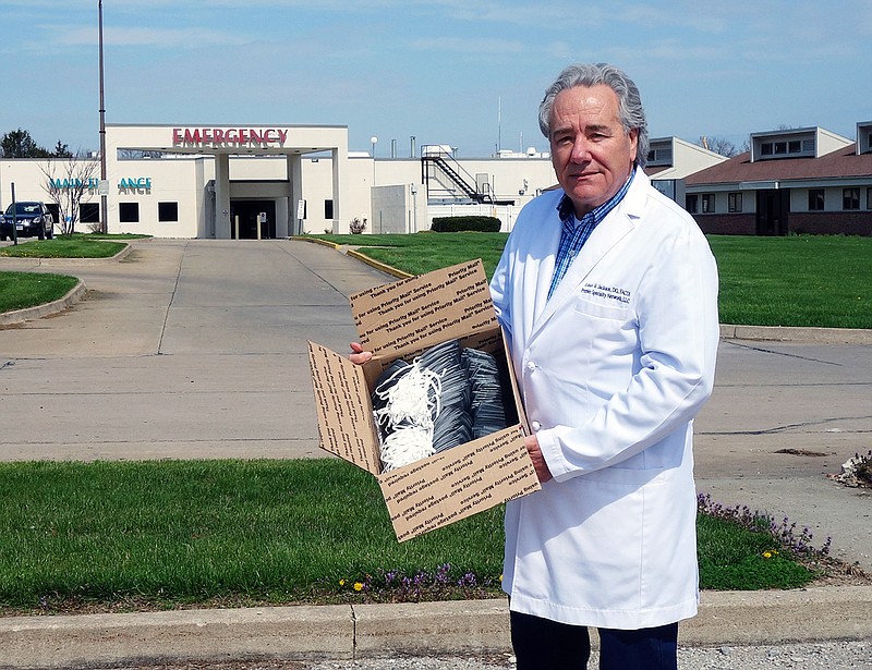Dr. Robert Jackson, the new chief medical officer at Fulton Medical Center, holds a boxful of mask on April 3.