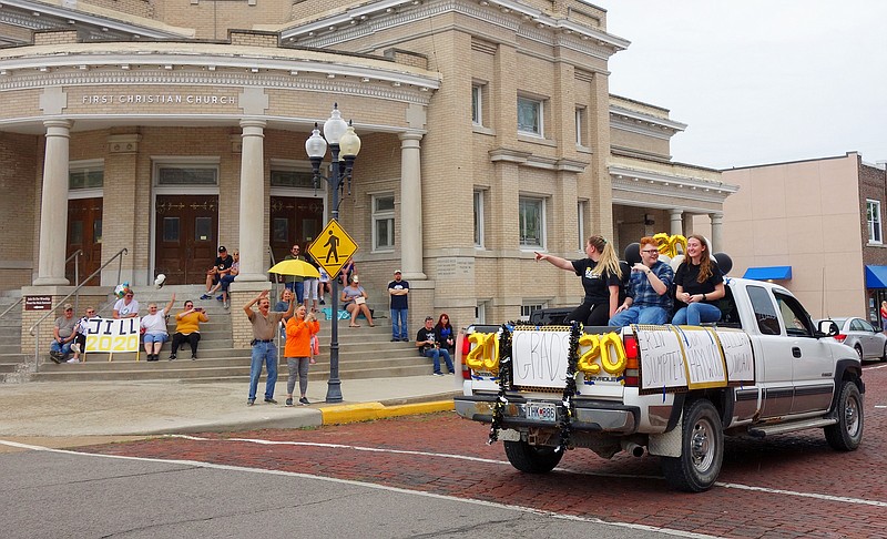 Riding in a pickup bed with friends Adom Haywood (center) and Erin Sumpter (right) during a May 22 parade for graduating seniors, Fulton High School grad Jillian Duncan waves to her family (far left). 'I think this is fun,' said her grandmother, Virginia Duffie. 'I told her I was part of the first FHS class to graduate in Champ Auditorium — that was the class of '66. Now she gets to be in the first class to have a street parade.'