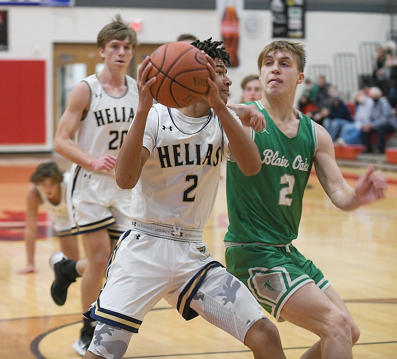 Carson Prenger of Blair Oaks tries to prevent Desmond White of Helias from driving to the basket during Monday afternoon's game at Fleming Fieldhouse.