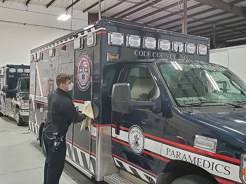 Cole County Paramedic Joseph Langhammer wipes down a county ambulance Tuesday afternoon after returning from a call.