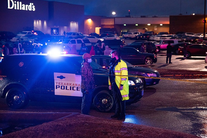 A Texarkana, Texas, police officer speaks to a bystander asking questions about a fatal shooting that took place in the parking lot of Chili's on Wednesday.
