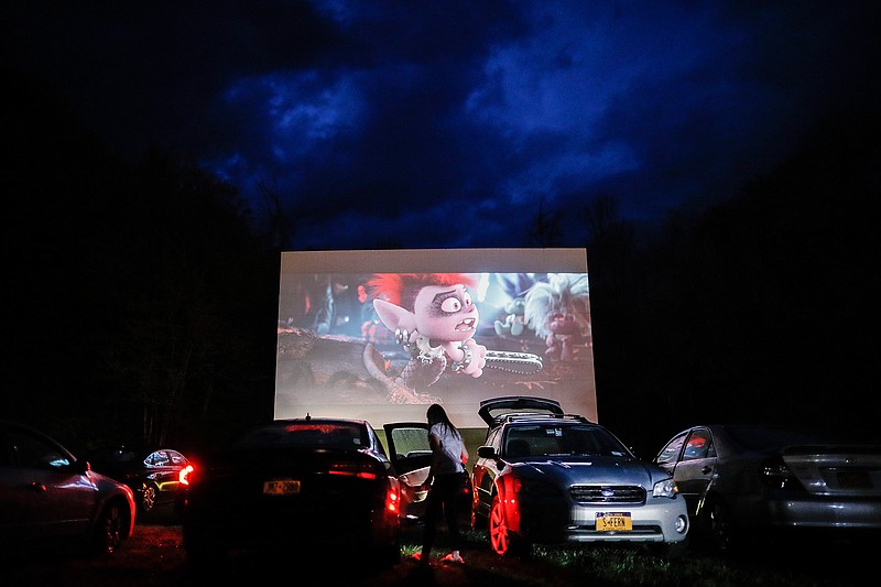 in this Friday, May 15, 2020, file photo, guests watch a showing of "Trolls World Tour," at the Four Brothers Drive In Theatre amid the coronavirus pandemic, in Amenia, N.Y. Most North American theaters weren't open for six months straight through the summer season, which typically accounts for around 40% of the year's profits. For the past two years, the summer movie season has netted over $4.3 billion. This year it brought in $176.5 million, much of that from drive-in theaters. (AP Photo/John Minchillo, File)