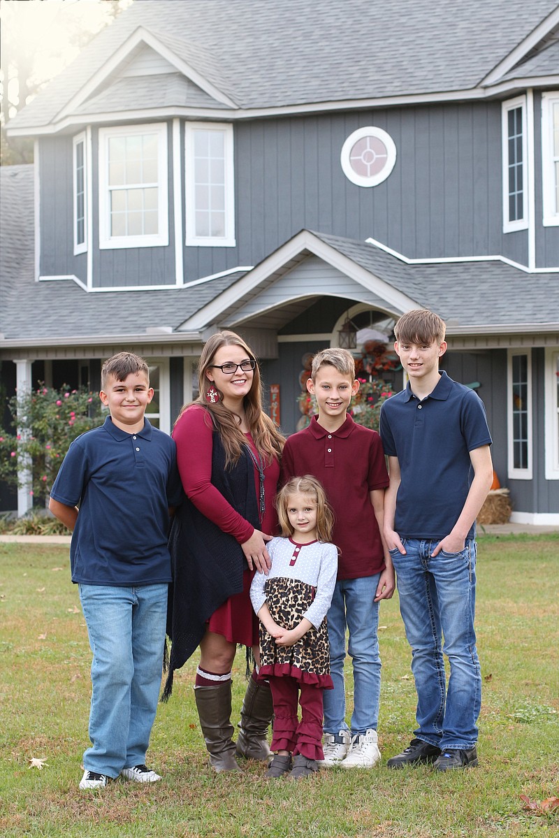 From left, Gunner, Christy Jimenez, Mikaleah (low row), Kaleb and Michael pictured in front of their new house.

(PHOTO BY KATIE STONE)