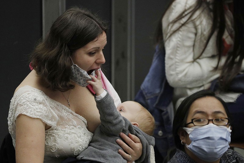 FILE - In this Wednesday, Oct. 21, 2020 file photo, Valentina Frey of Switzerland breasts feed her daughter, Charlotte Katharina, in the Paul VI hall on the occasion of the weekly general audience at the Vatican. Pope Francis at the start of his audience mentioned her as an example of tenderness and beauty. Released on Tuesday, Dec. 29, 2020, the first U.S. government dietary guidelines for infants and toddlers recommend exclusive feeding of breast milk for at least six months and no added sugar for children under age 2. (AP Photo/Gregorio Borgia)