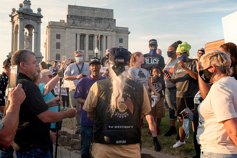 A group of protesters and counterprotesters gather on a hot summer's evening June 19, 2020, at the nearly 103-year-old Confederate monument during a peaceful demonstration in favor of removing the statue from downtown Texarkana. 
