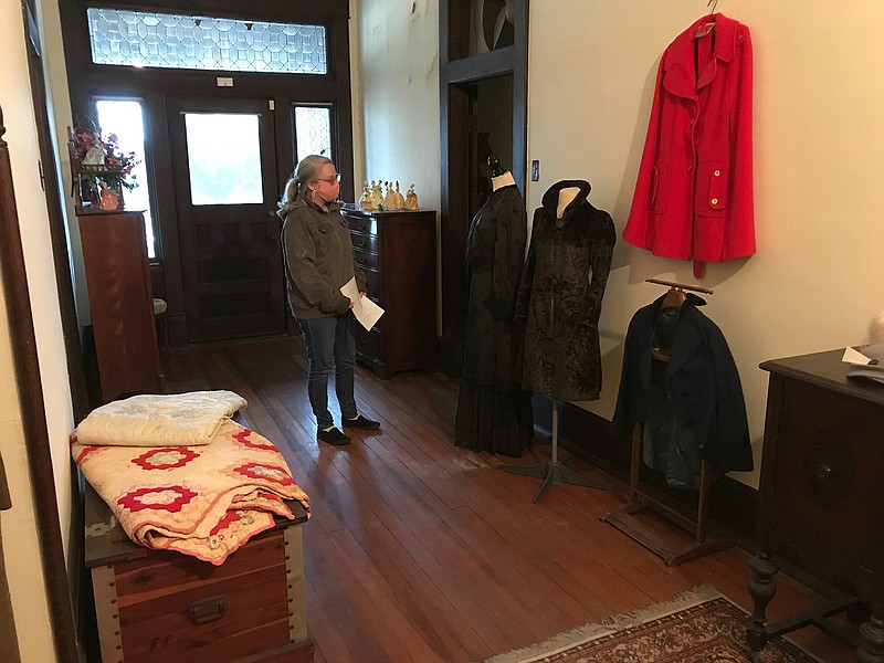 Donna Bonjuor, a docent for the Texarkana Museums System, studies a collection of assorted ladies' clothing and winter wear on display inside the system's 1905 P.J. Ahern Home.