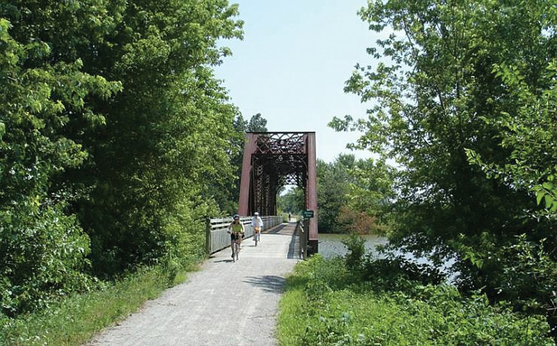 Bike riders cross over a bridge on the Katy Trail.