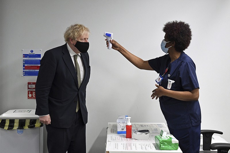 Britain's Prime Minister Boris Johnson has his temperature checked Monday during a visit to Chase Farm Hospital in north London. Johnson warned Sunday that more onerous lockdown restrictions in England are likely in the coming weeks.