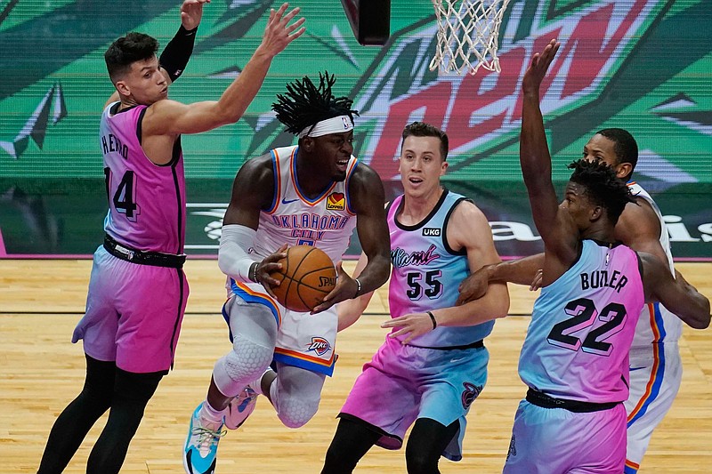 Oklahoma City Thunder guard Luguentz Dort (5) grabs a rebound surrounded by Miami Heat forward Duncan Robinson (55), forward Jimmy Butler (22) and guard Tyler Herro (14), during the first half of an NBA basketball game, Monday, Jan. 4, 2021, in Miami. (AP Photo/Marta Lavandier)