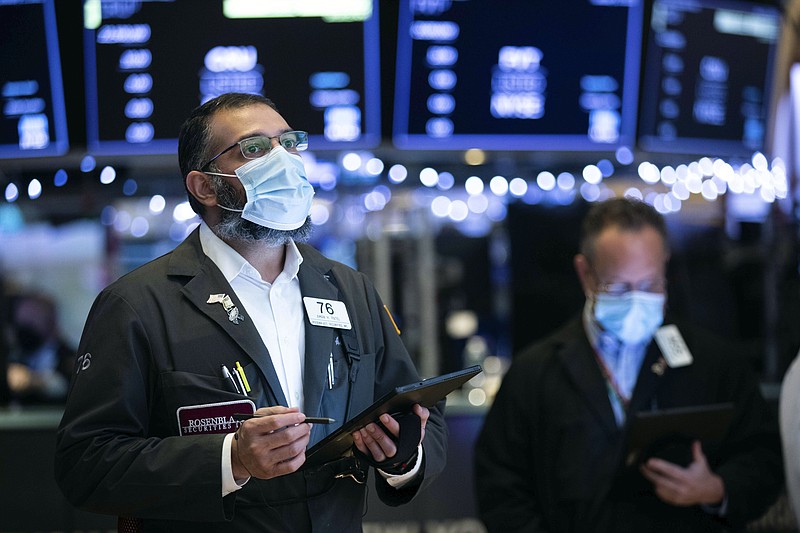 In this photo provided by the New York Stock Exchange, traders work on the floor, Tuesday, Jan. 5, 2021. U.S. stocks are wobbling between small gains and losses on Tuesday, a day after dropping to their worst loss in months amid the worsening pandemic and potentially market-moving Senate elections. (Colin Ziemer/New York Stock Exchange via AP)
