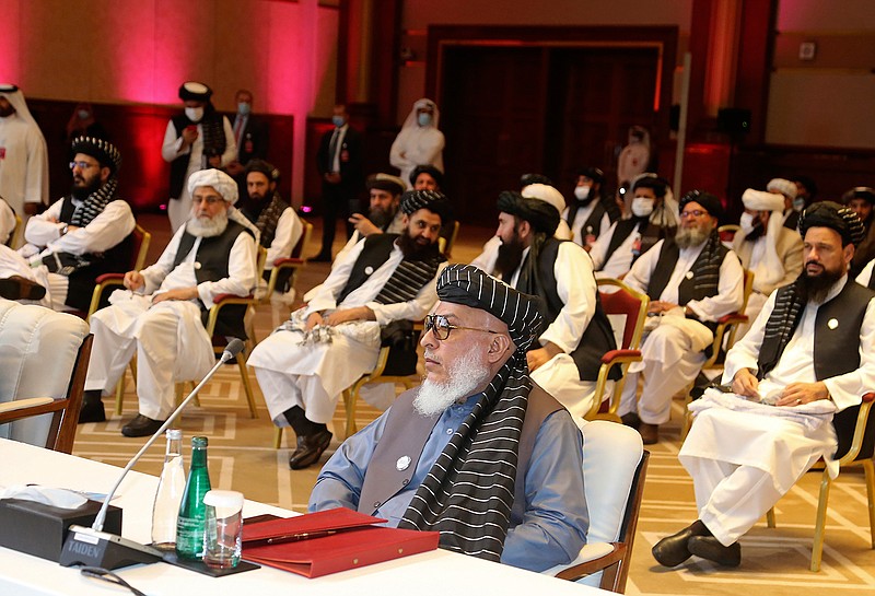  In this Sept. 12, 2020, file photo, Taliban negotiator Abbas Stanikzai, center front, and his delegation attend the opening session of peace talks between the Afghan government and the Taliban, in Doha, Qatar. Afghan negotiators are to resume talks Tuesday, Jan. 5, 2021, aimed at finding an end to the decades of relentless conflict, even as hopes are waning, and frustration and fear is growing over a spike in violence that has combatants on both sides blaming the other. (AP Photo/Hussein Sayed, File)