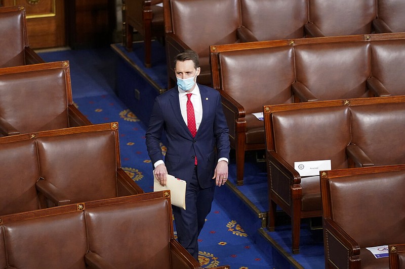 Sen. Josh Hawley, R-Mo., walks into the House chamber before a joint session of the House and Senate convenes to count the electoral votes cast in November's election, at the Capitol, Wednesday, Jan 6, 2021. (AP Photo/Andrew Harnik)