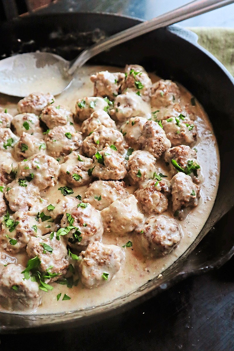 Roasted Swedish meatballs are served in a rich, roux-based gravy made with beef broth, heavy cream and sour cream. Cranberry sauce adds a bright and tangy garnish. (Gretchen McKay/Pittsburgh Post-Gazette/TNS)
