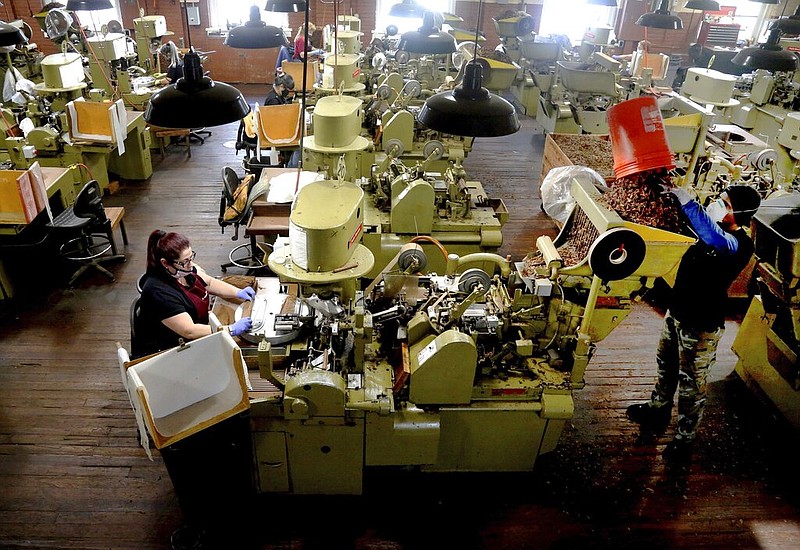  In this Dec. 14, 2020 file photo, Zeida Hernandez, of Tampa, Fla., left, makes Factory Throwout cigars using an antique hand-operated cigar machine at the J.C. Newman Cigar Co., Tampa's last cigar factory, in Fla. 