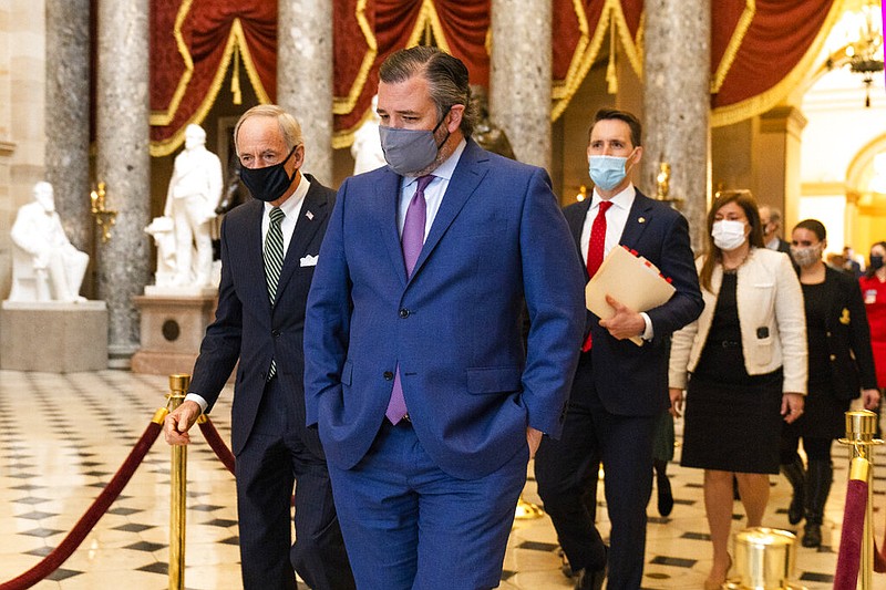 Sen. Ted Cruz, R-Texas, front, followed by Sen. Josh Hawley, R-Mo., walk from the House Chamber following a Senate procession carrying boxes holding Electoral College votes to the House Chamber for a joint session to confirm the Electoral College votes, Wednesday, Jan. 6, 2021, in Washington. (AP Photo/Manuel Balce Ceneta)