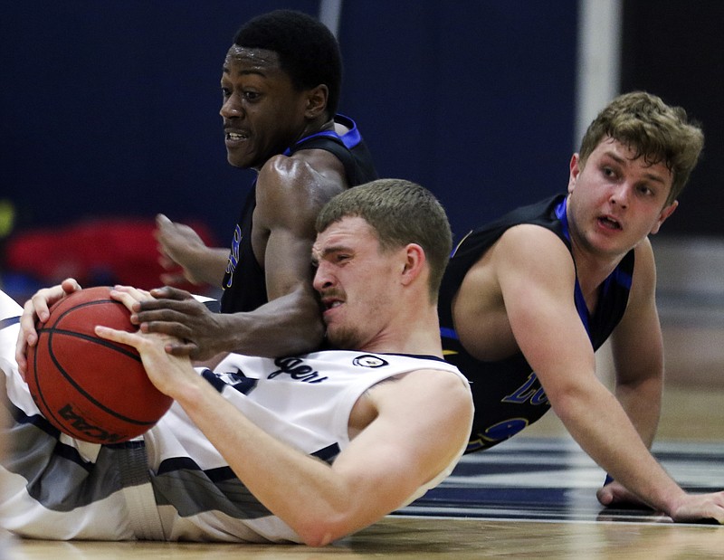 Lincoln forward Jordan Notch and Nebraska-Kearney guards RJ Pair and Jake Walker battle for a loose ball on the floor during Thursday's game at Jason Gym.