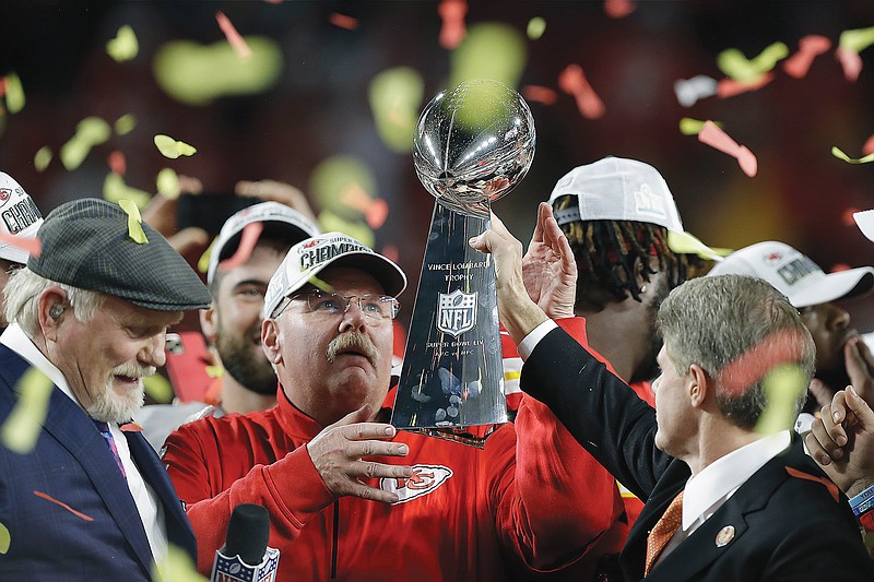 In this Feb. 2, 2020, file photo, Chiefs chairman Clark Hunt hands the Lombardi Trophy to coach Andy Reid after Kansas City's win against San Francisco in Super Bowl 54 in Miami Gardens, Fla.