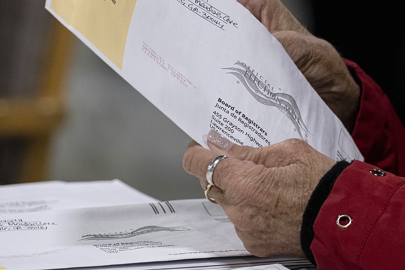 Workers at the Gwinnett County Georgia elections headquarters process absentee ballots for Georgia's Senate runoff election in Lawrenceville, Ga. on Wednesday,  Jan. 6, 2021. (AP Photo/Ben Gray)