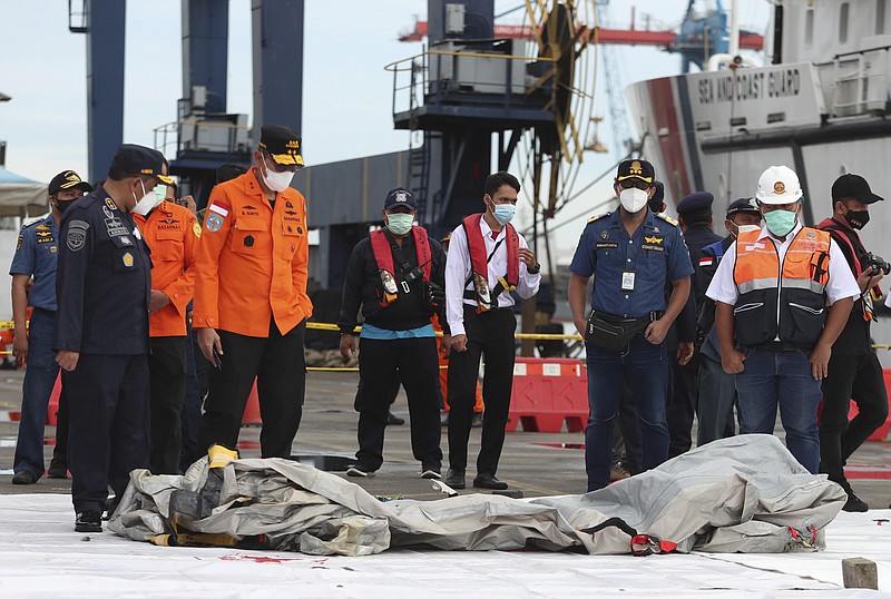 Rescuers inspects found in the waters around the location where a Sriwijaya Air passenger jet has lost contact with air traffic controllers shortly after the takeoff, at the search and rescue command center at Tanjung Priok Port in Jakarta, Indonesia, Sunday, Jan. 10, 2021. The Boeing 737-500 took off from Jakarta for Pontianak, the capital of West Kalimantan province on Indonesia's Borneo island, and lost contact with the control tower a few moments later. (AP Photo/Achmad Ibrahim)