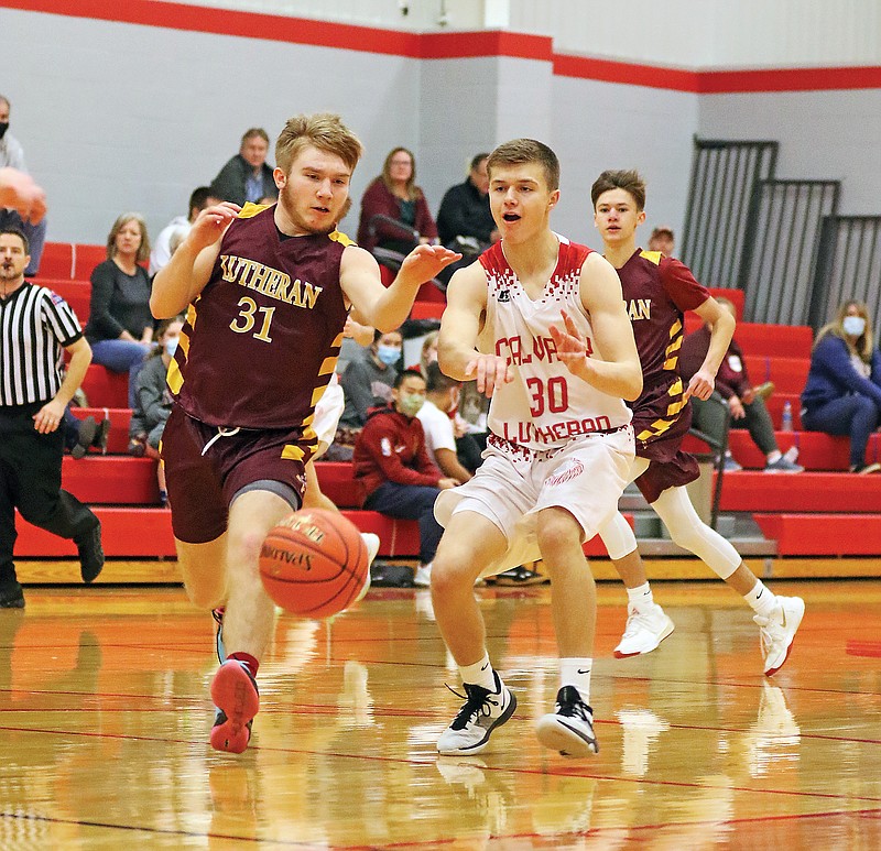 Calvary Lutheran's Jonathan Lieb bounces a pass in the post as Kansas City Lutheran's Rex Lyle defends Saturday at Calvary Lutheran.