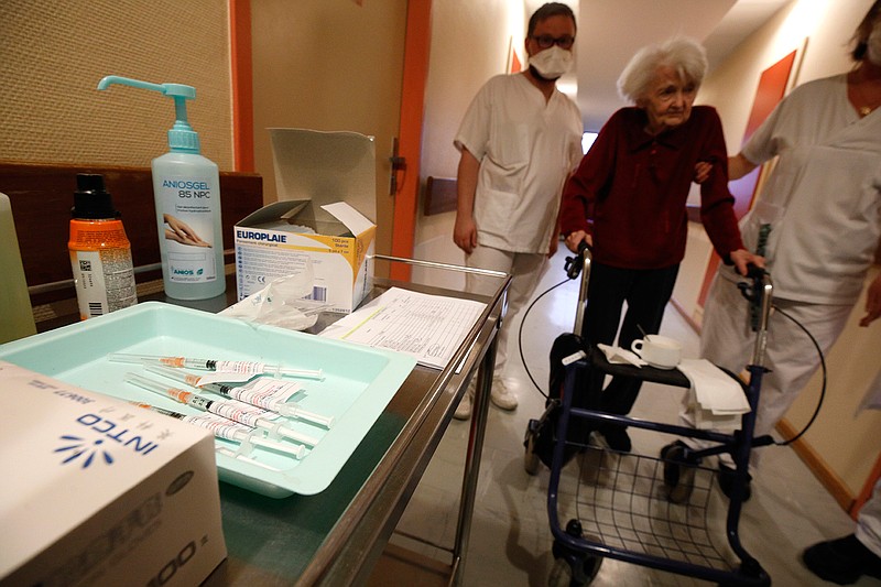 In this Jan. 6, 2021, file photo, a resident is led to get the Pfizer-BioNTech COVID-19 vaccine at the Bois Fleuris nursing home in Strasbourg in eastern France. As France examines why its vaccination campaign has started so slowly, the answer lies partly in the red tape and the government's decision to start with perhaps the toughest group to reach: the elderly in nursing homes. (AP Photo/Jean-Francois Badias, File)