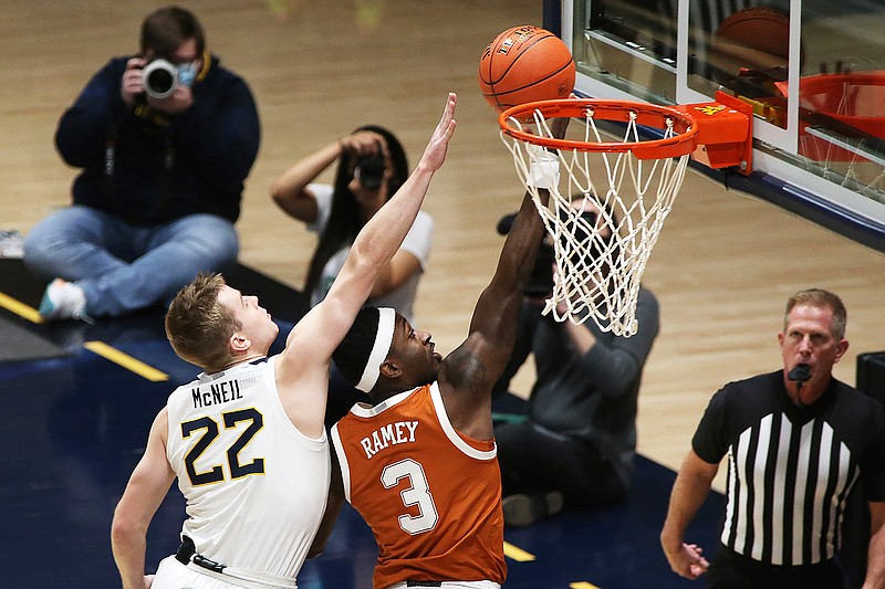 Texas guard Courtney Ramey (3) shoots past West Virginia guard Sean McNeil (22) during the first half of an NCAA college basketball game Saturday, Jan. 9, 2021, in Morgantown, W.Va. (AP Photo/Kathleen Batten)