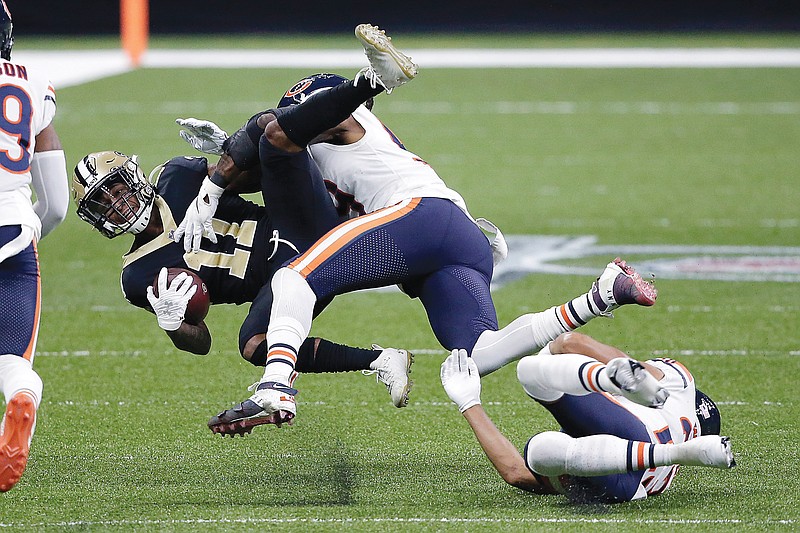 Saints wide receiver Deonte Harris is tackled by Bears linebacker Danny Trevathan and cornerback Kyle Fuller (right) during Sunday's NFC wild-card game in New Orleans.
