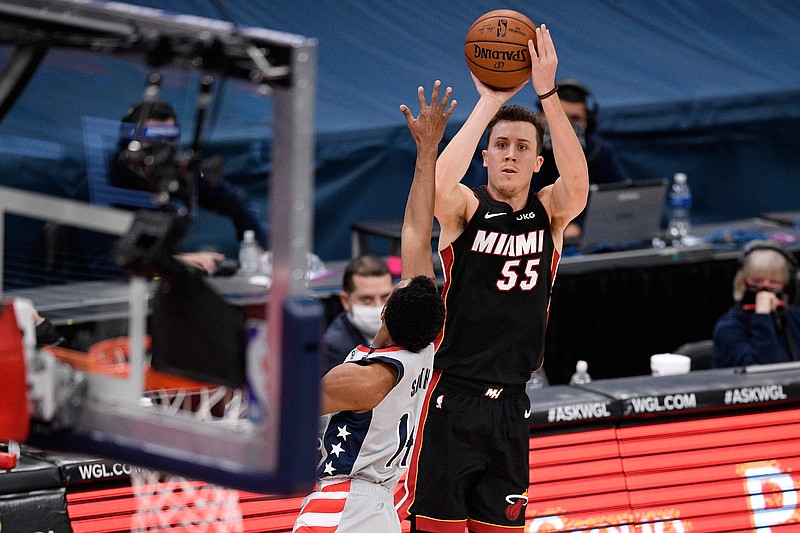 Miami Heat guard Duncan Robinson (55) shoots as he is defended by Washington Wizards guard Ish Smith (14) during the second half of an NBA basketball game, Saturday, Jan. 9, 2021, in Washington. (AP Photo/Nick Wass)