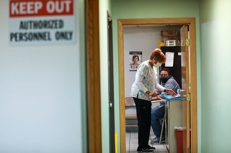 Registered Nurse Valenthia Gamble, of Eastpointe, sees a patient, Dale Dorsey, 27, of Detroit in what used to be one of the restrooms at the HUDA clinic on the west side of Detroit on Tuesday, Dec. 29, 2020.    (Kimberly P. Mitchell/ Detroit Free Press/TNS)